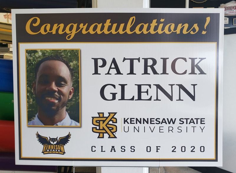 Graduation sign in black and yellow lettering.