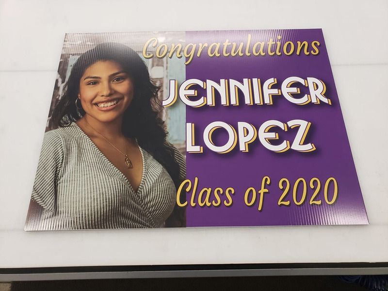 Graduation sign in purple and white lettering.